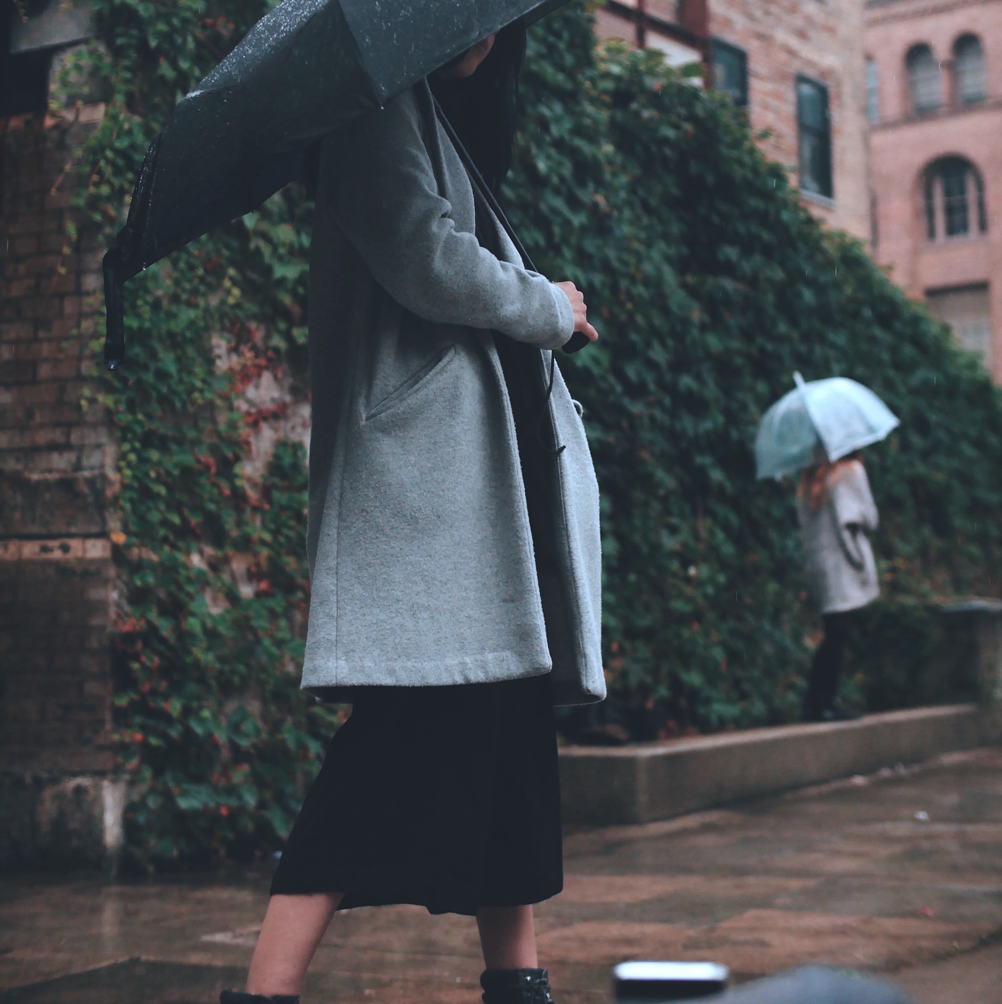 Woman in the street, wearing a coat and holding an umbrella